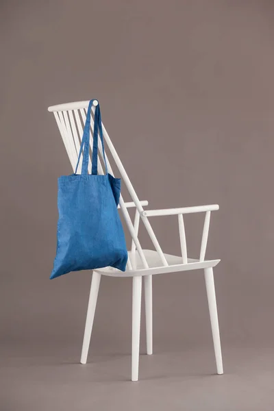 Bolso azul colgado en una silla blanca —  Fotos de Stock