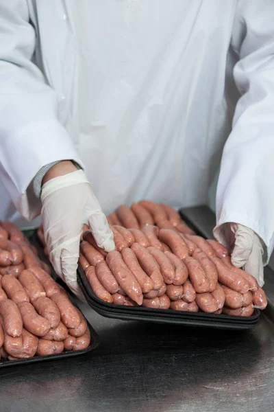 Açougueiro embalagem salsichas cruas — Fotografia de Stock