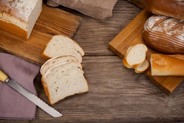 Various bread loaves with slices — Stock Photo, Image