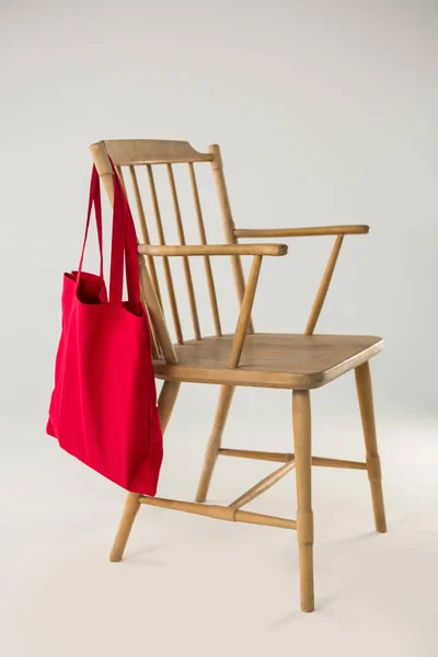 Borsa rossa appesa a una sedia di legno — Foto Stock