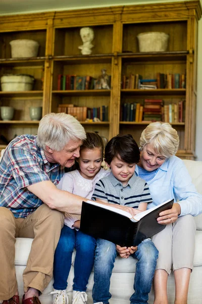 Grootouders en kleinkinderen kijken naar fotoalbum — Stockfoto