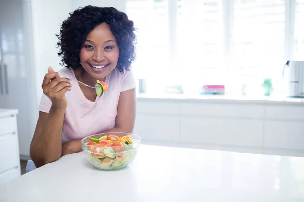 Leende kvinna äter sallad — Stockfoto