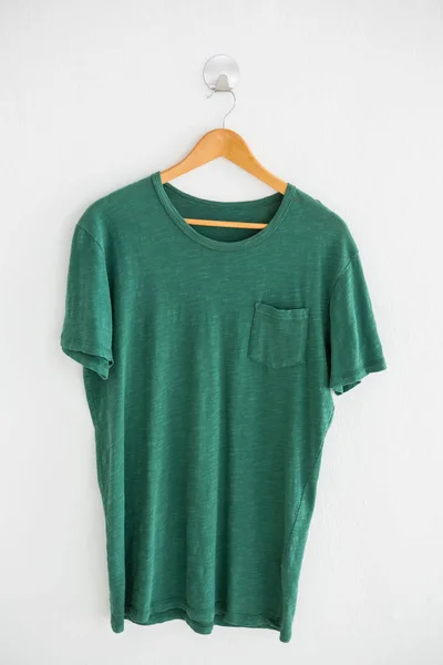 Green t-shirt with pocket on hanger — Stock Photo, Image