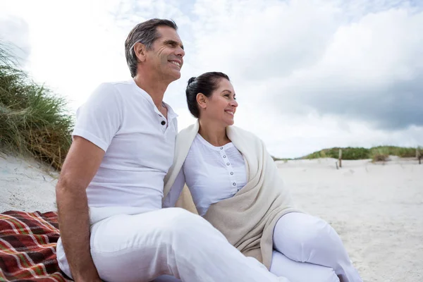 Paret sitter på sand på stranden — Stockfoto