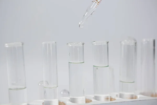 Química cayendo en tubos de ensayo — Foto de Stock