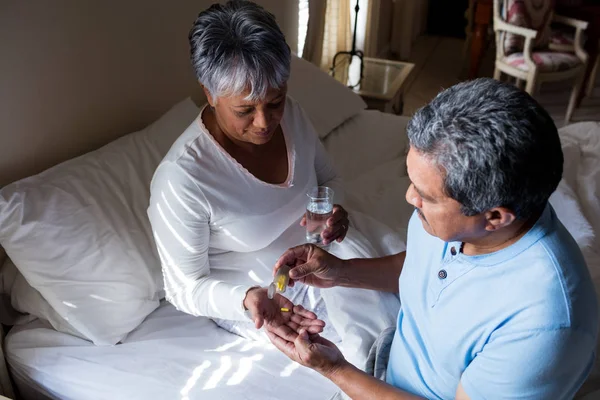 Senior man vrouw geven geneeskunde — Stockfoto