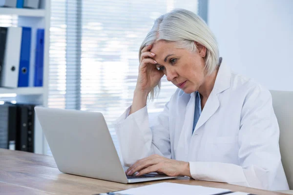 Spänd kvinnliga läkare arbetar på hennes laptop — Stockfoto