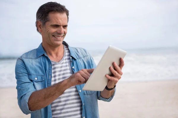 Man met digitale tablet op strand — Stockfoto