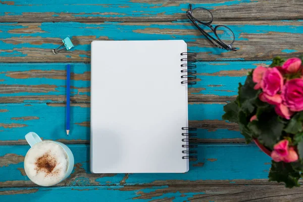 Coffee with notepad and flower vase