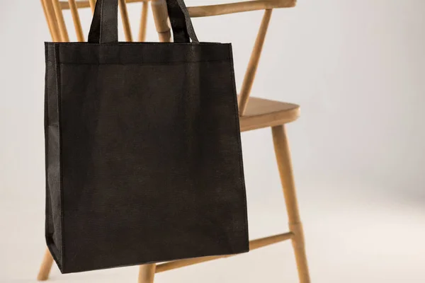 Чорна сумка, що висить на дерев'яному стільці — стокове фото