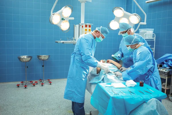 Equipe de cirurgiões que realizam a operação — Fotografia de Stock