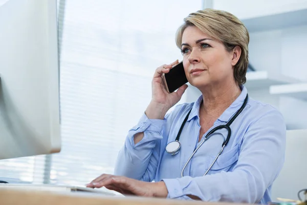 Женщина-врач разговаривает по телефону — стоковое фото