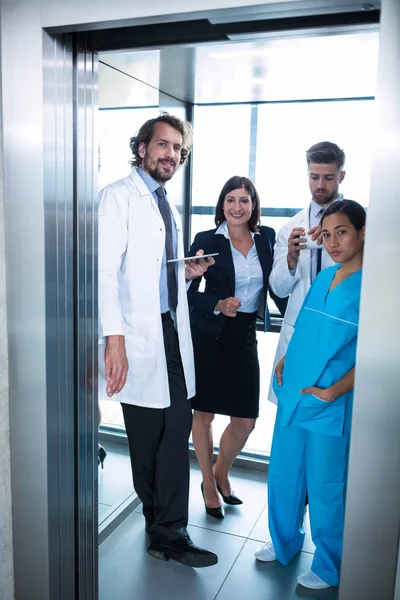 Médecins et femme d'affaires debout dans l'ascenseur — Photo