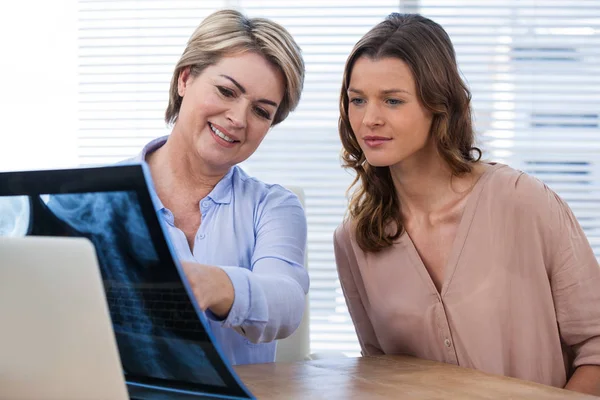 Ärztin erklärt Patientin Röntgenbericht — Stockfoto