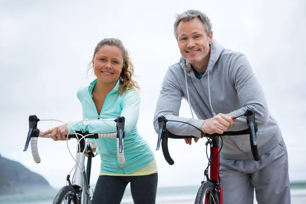 Paar lehnt am Strand auf Fahrrad — Stockfoto