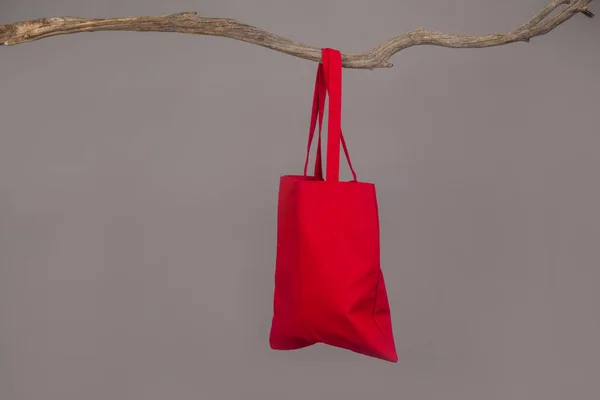 Красная сумка висит на ветке дерева — стоковое фото