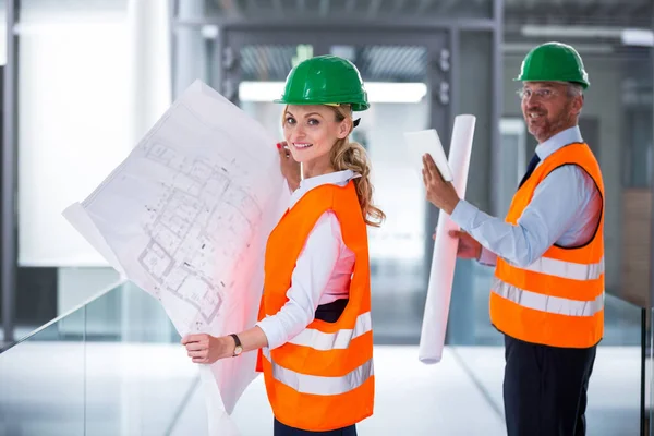 Architects standing with blueprint — Stock Photo, Image