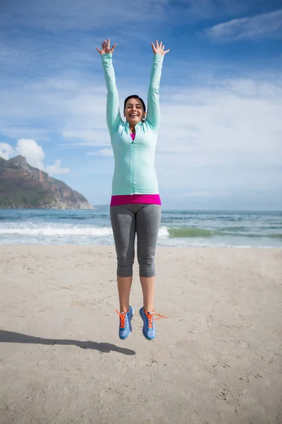 Opgewonden vrouw springen op strand — Stockfoto