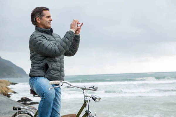 Mann auf Fahrrad fotografiert am Telefon — Stockfoto