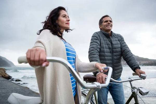 Paar steht mit Fahrrad am Strand — Stockfoto