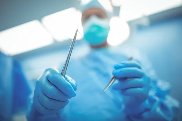 Surgeon holding surgical tools — Stock Photo, Image