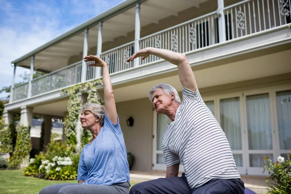 Starší pár provádět protahovací cvičení — Stock fotografie