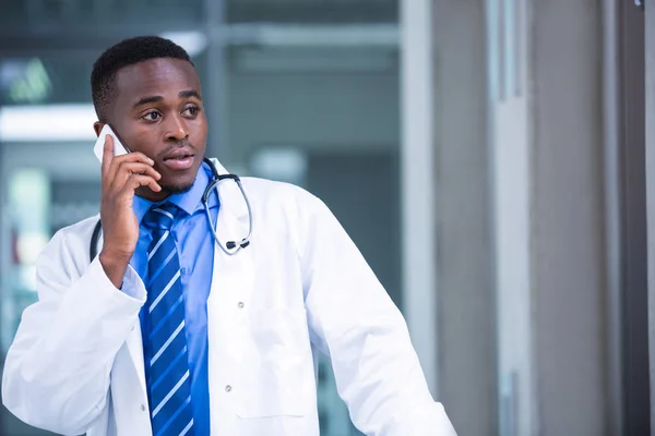 Verkrampte arts praten op mobiele telefoon — Stockfoto