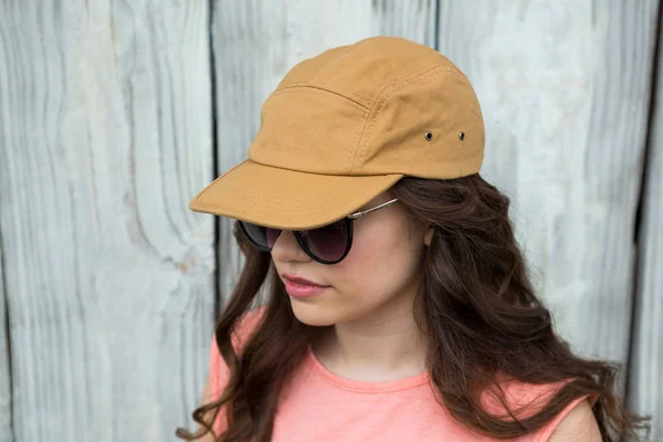 Femme en casquette marron et lunettes de soleil — Photo