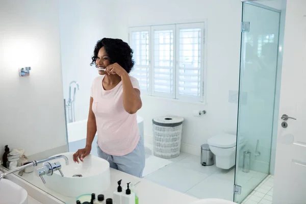 Woman brushing her teeth in bathroom — Stock Photo, Image