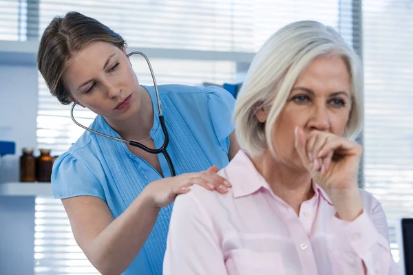 Médico examinando paciente tosiendo — Foto de Stock