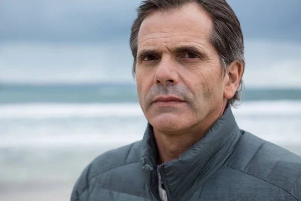 Hombre serio en la playa durante el invierno — Foto de Stock