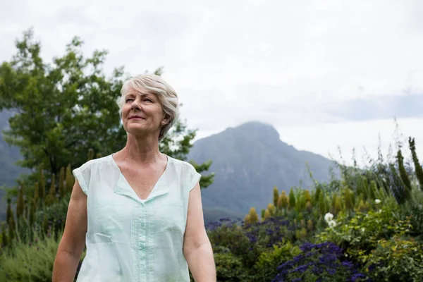 Senior kvinna som står i gräsmatta — Stockfoto