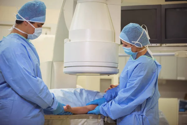 Chirurgiens examinant patient en salle d'opération — Photo