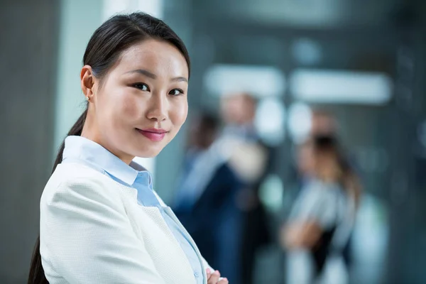 Confident businesswoman standing with her arms crossed — Stock Photo, Image