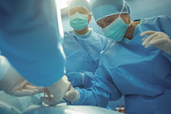 Хірурги, що виконують операцію в операційному театрі — стокове фото