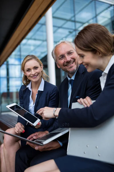 Businesspeople discussing over laptop and tablet — Stock Photo, Image