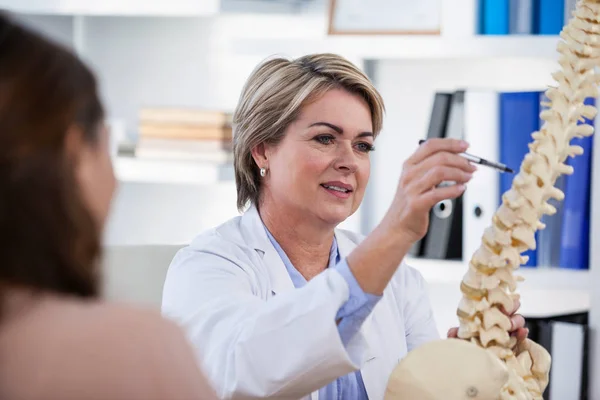 Médico que explica a coluna anatômica ao paciente — Fotografia de Stock