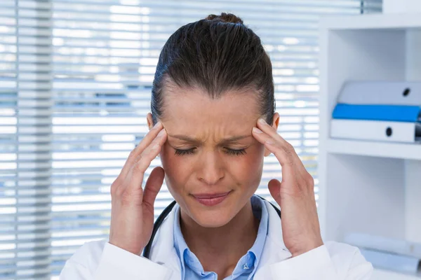 Fatigué femme médecin ayant mal à la tête — Photo