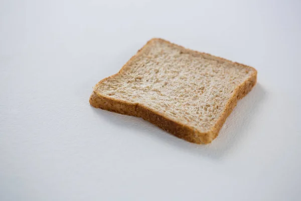 Fetta di pane singola su bianco — Foto Stock