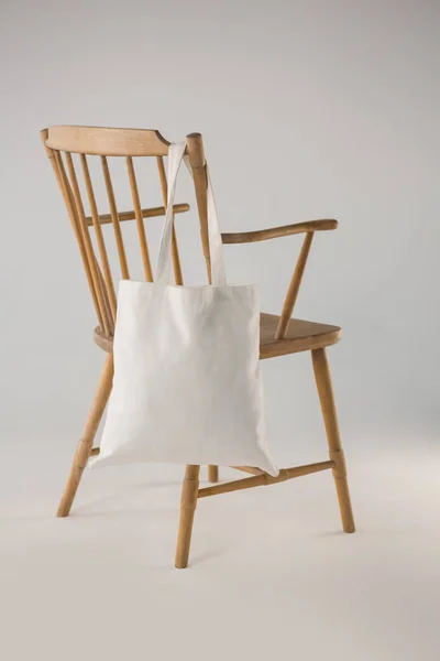 Borsa bianca appesa a una sedia di legno — Foto Stock