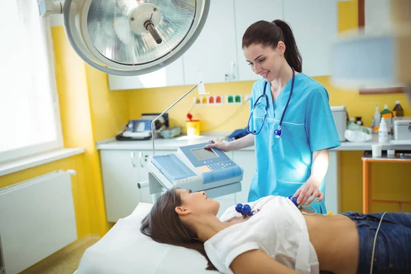 Enfermeira realizando um eletrocardiograma no paciente — Fotografia de Stock