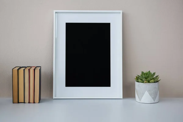 Boeken, afbeeldingsframe en pot plant — Stockfoto