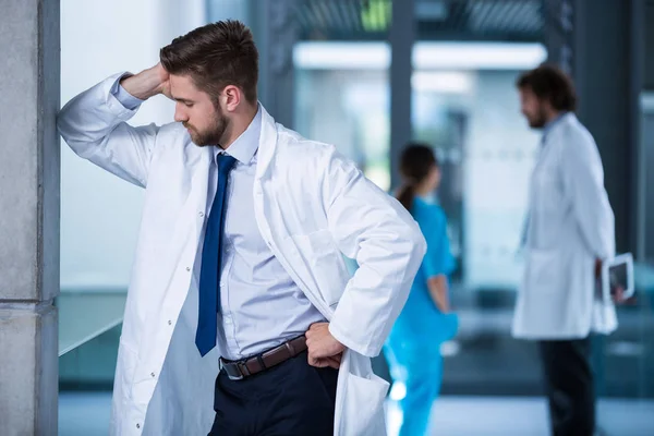 Stressed doctor standing in hospital — Stock Photo, Image