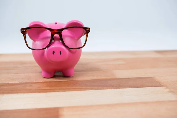 Yakın çekim gözlük ile piggy banka — Stok fotoğraf