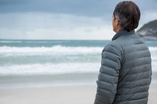 Nadenkende man die op strand — Stockfoto