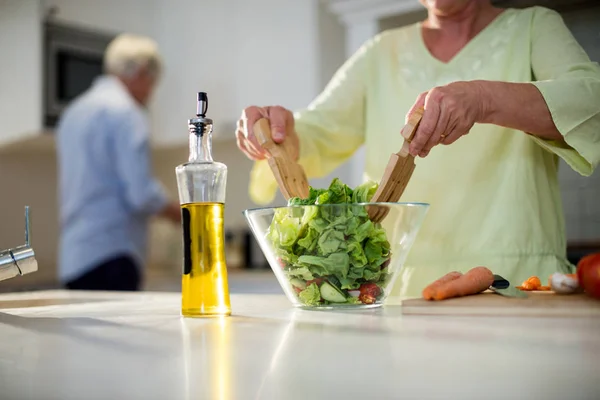 Senior woman preparing vegetable salad — Stock Photo, Image