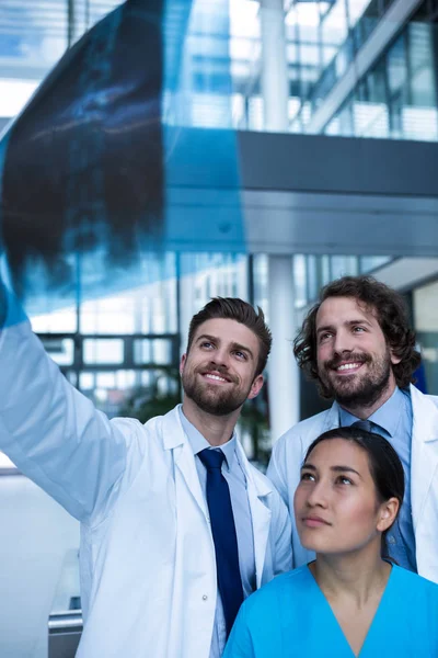 Läkare och sjuksköterska undersöker röntgen rapport — Stockfoto