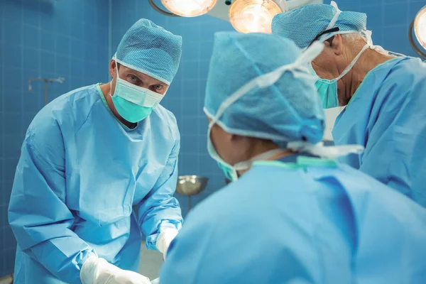 Equipe de cirurgiões que realizam a operação — Fotografia de Stock