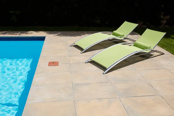 Two empty sun lounger on poolside — Stock Photo, Image