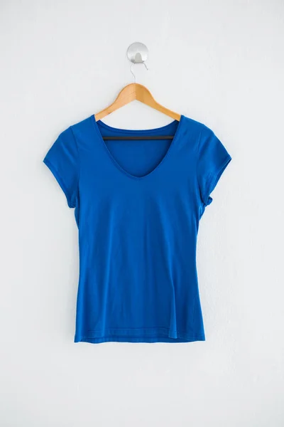 Blue t-shirt hanging on wall — Stock Photo, Image